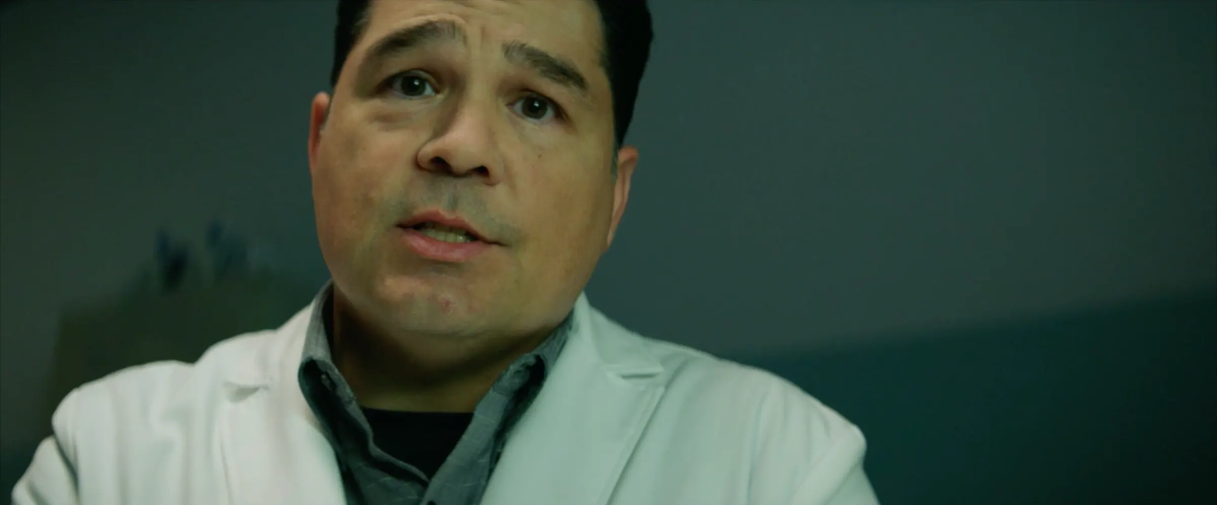 A doctor in a white coat speaks to camera.