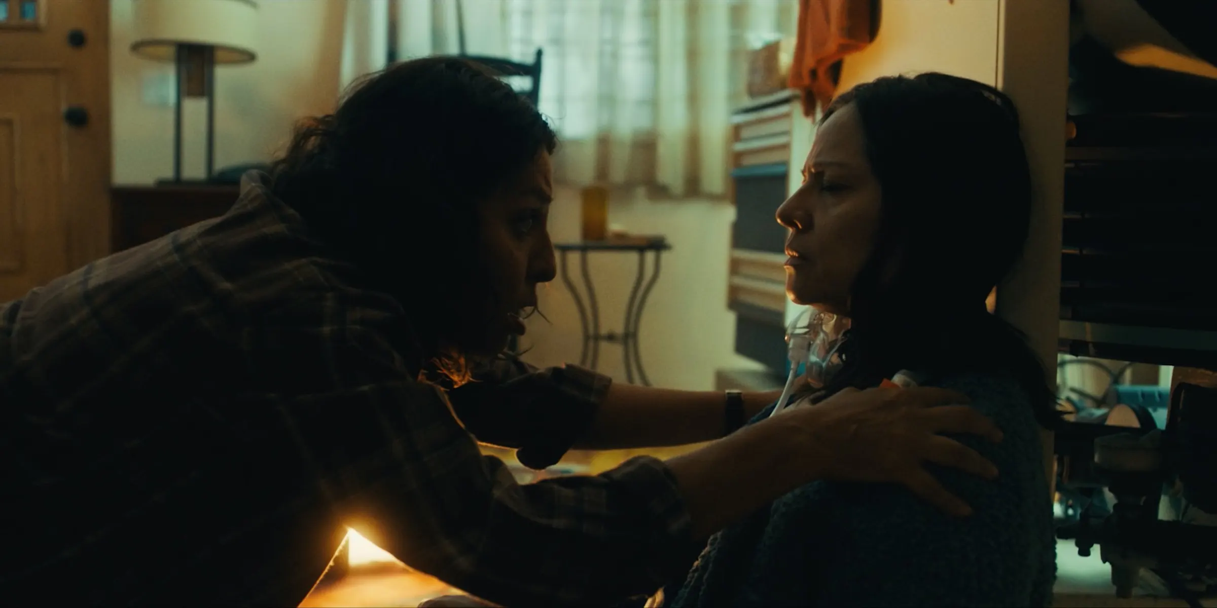 Two sisters share a quiet moment by lamplight.