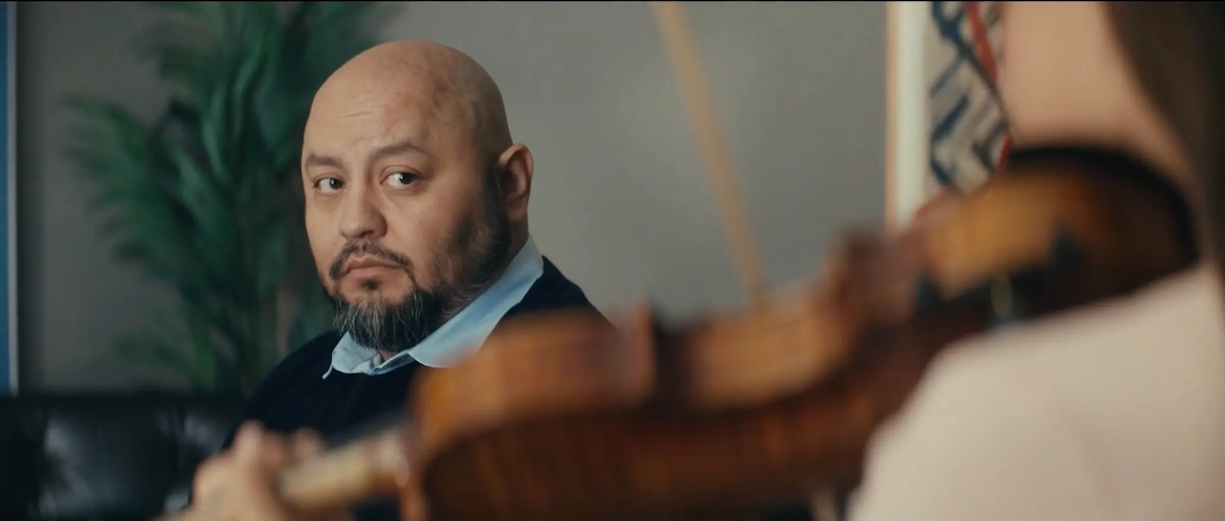 A man in a suit watches from the audience.