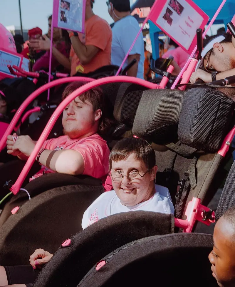 A young Angel Rider waits in a pink racing chair.